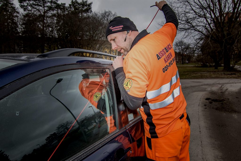 Assistancekåren vägassistans öppnar bildörr till förare som tappat sin nyckel